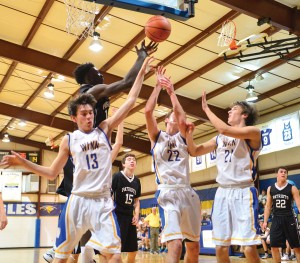 Noah Edwards (13), Mitchell Gibbons (22) and Gunnar Hensley (21) do battle under the basket. (Photo/Ross Burton)