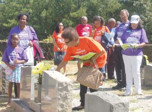 Nancy Juanita Thompson, named for her grandmother and Thompson family matriarch, Nancy Thompson, places flowers on the grave of her father, Ed Brice Thompson (one of Nancy’s sons) last weekend during the first reunion of the Thompson descendants in Blair. (Photo/Barbara Ball)