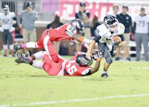Westwood’s Trayshawn Miller (52) and Ellis Hawkins (45) can’t get a handle on York quarterback Ethan Mitchell. (Photo/Ross Burton)